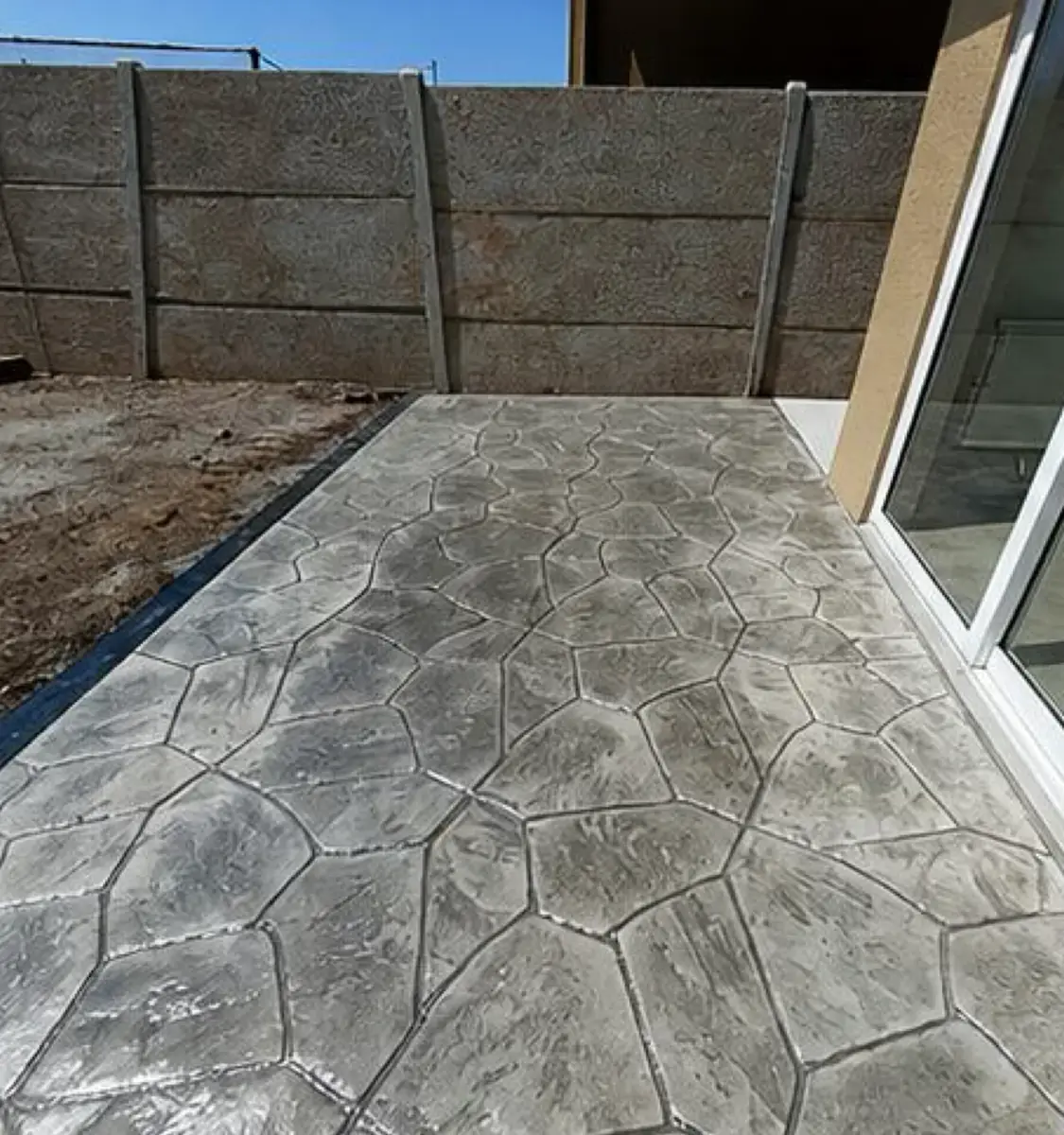 Patio con hormigón estampado tipo piedra laja en gris